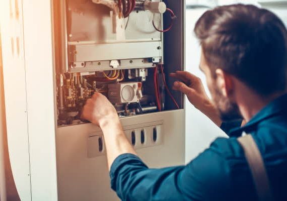 Repairman fixing a broken electric boiler or furnace with focus on his hand. High quality generative ai